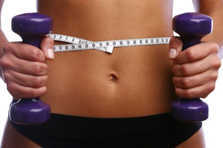 Fitness dumbbells in the hands of a fit girl